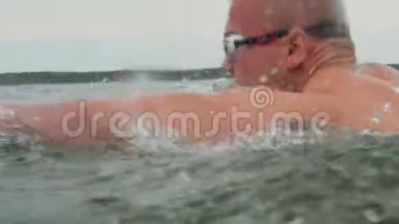 肌肉发达的年轻男性三项运动员游泳时戴着泳镜视频的预览图