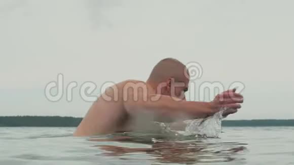 在湖边游泳的肌肉运动员视频的预览图