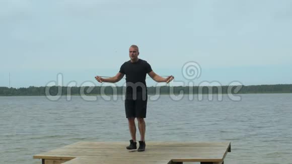 健身帅哥跳跳绳在公园的码头视频的预览图
