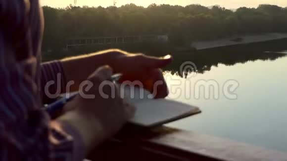 雄手在日落的河桥上放下一些视频的预览图