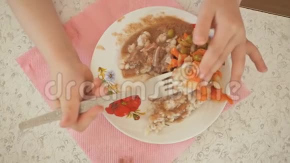 在幼儿园吃午饭一个孩子正在吃一个配菜配菜是盘子里的蔬菜一个孩子的手特写视频的预览图