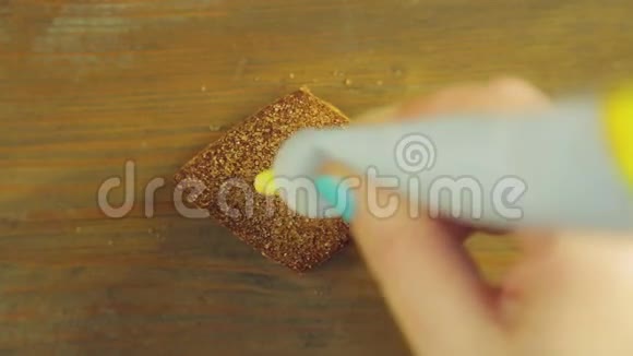 一只手握着一管烹饪颜料在带有黄色颜料的巧克力饼干上画出滑稽的面孔视频的预览图