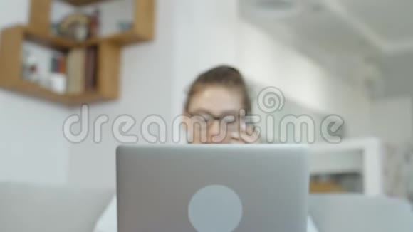 快乐女孩在家里用手提电脑在社交网络上聊天微笑视频的预览图