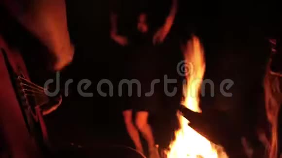 快乐的朋友在晚上在篝火旁弹吉他跳舞视频的预览图