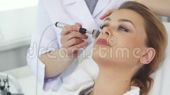 美容师用离子电泳辊涂客户的面部视频的预览图