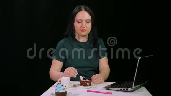 一个黑黑肤色的女人正在咖啡馆里喝咖啡吃蛋糕视频的预览图
