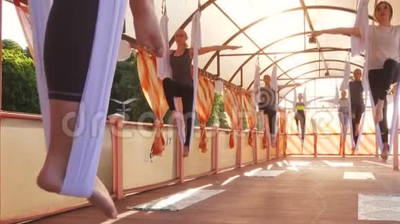 在户外做空中瑜伽运动的年轻女性视频的预览图