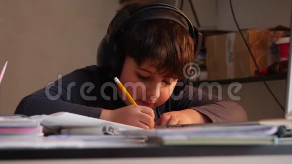 一个戴着大耳机的男孩正在写作业视频的预览图