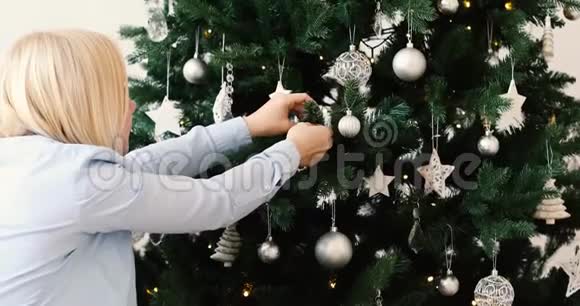 金发女人摘冰玩具圣诞树视频的预览图