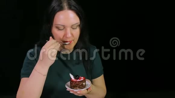 一个黑色背景的黑发女人正在喝咖啡和吃蛋糕视频的预览图