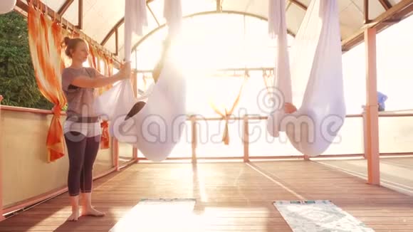 在户外做空中瑜伽运动的年轻女性视频的预览图