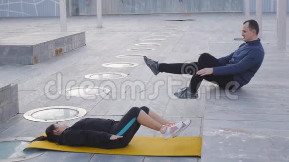与户外私人教练一起健身女人躺在黄色的垫子上骑自行车教练证明了正确视频的预览图