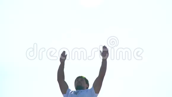 一个在阳光下的男人在蹦床上跳着做着一个跟头的动作动作很慢视频的预览图