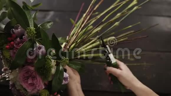 美丽的雌性手在黑暗的表面上用子切割花茎花卉工作室顶级射击视频的预览图