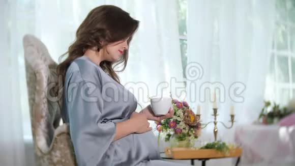 带茶的迷人孕妇视频的预览图