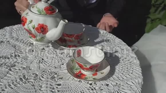 人们把茶倒在一个有茶壶的杯子里坐在咖啡馆里视频的预览图