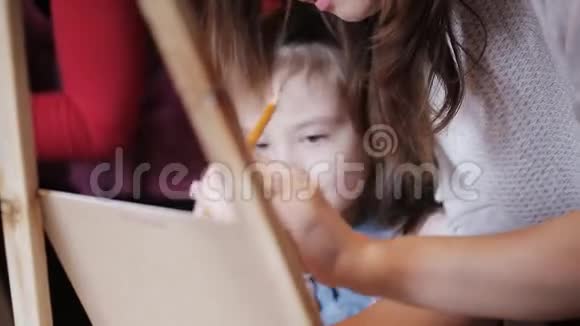 艺术家教一个小女孩在画布上画画绘图室视频的预览图