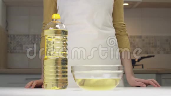 女人把油倒进透明的碗里视频的预览图