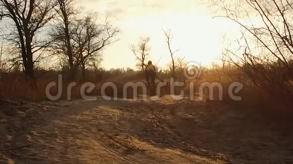 一个骑自行车的人骑着一辆山地车在一条土路上在寒冷的天气日落时在田野里的乡村道路上纪律交叉视频的预览图