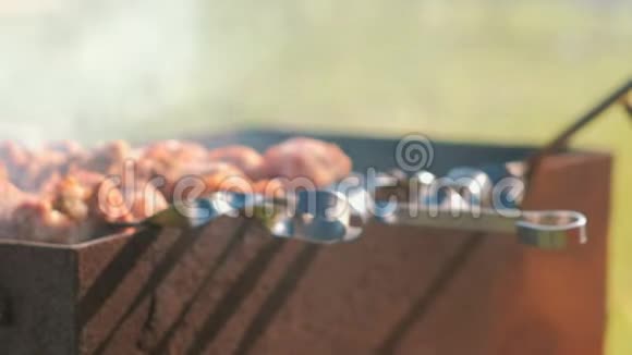 男人在后院的炭火烤架上烹制肉泥特写的手视频的预览图