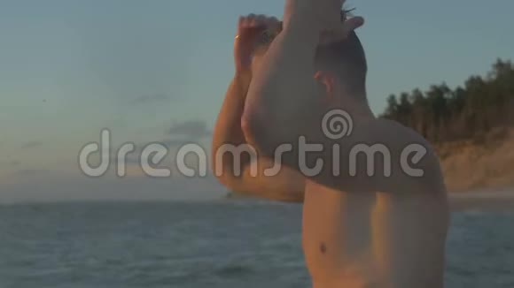 英俊的运动员在美丽的海滩看日落4k视频视频的预览图