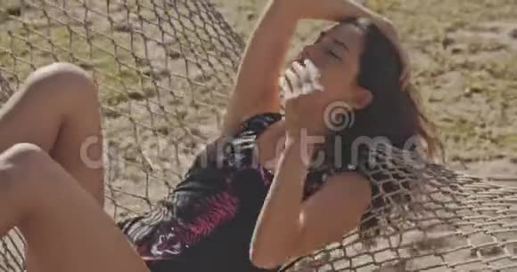 在热带海滩吊床上的女人异国情调放松生活方式广告商业理念佳能近景视频的预览图