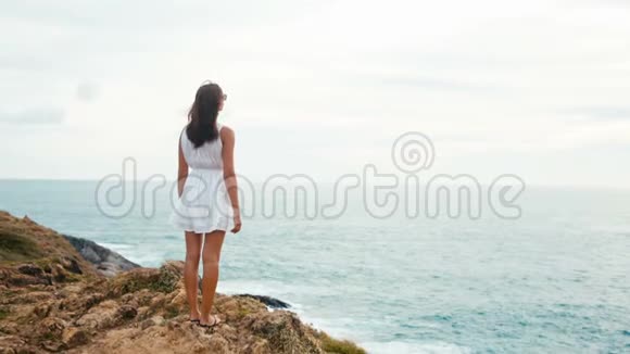 在海边悬崖边欣赏日落的女人视频的预览图