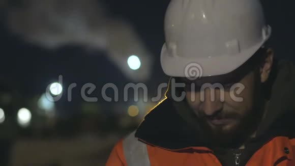 近距离拍摄工人使用智能手机在黄昏夜班概念4k视频的预览图