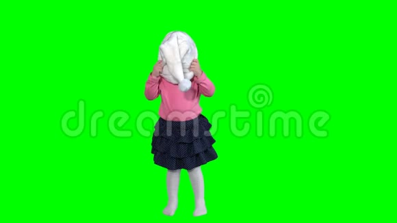 疯狂的小女孩摘下圣诞老人的帽子扔掉被隔离在绿色上视频的预览图
