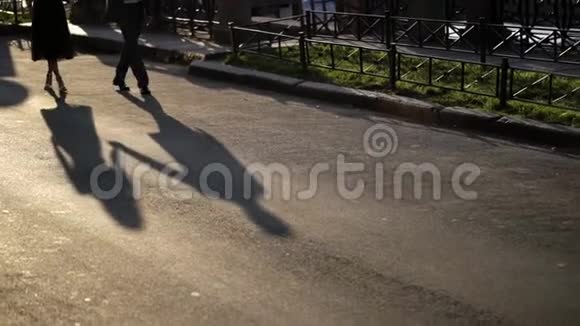 男人和年轻的女人走在街上两个人一大早就在一条城市街道上牵手约会影子视频的预览图