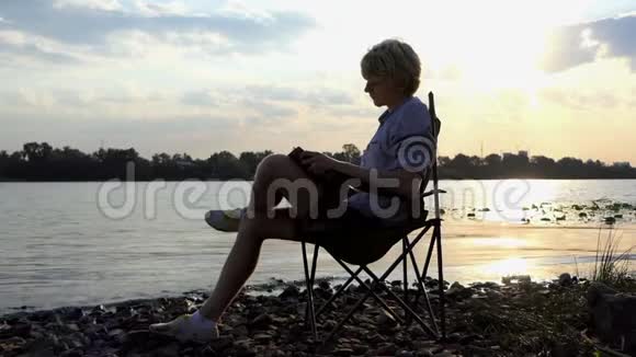 聪明的人在日落时折叠椅上做放松运动视频的预览图