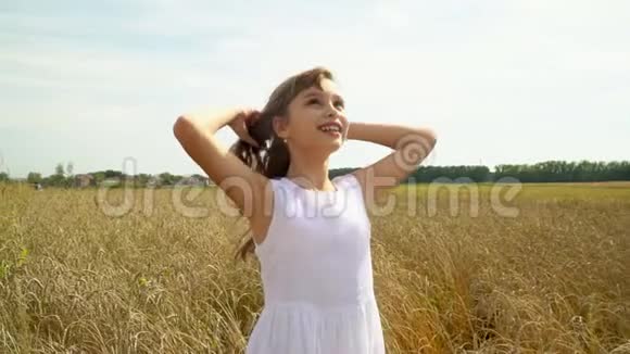 穿着白色连衣裙的女孩穿过金色小麦的田野这个美丽的女孩喜欢俄罗斯的开放空间视频的预览图