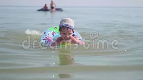 一个孩子在海里的一个充气圈上游泳快乐的童年积极情绪视频的预览图