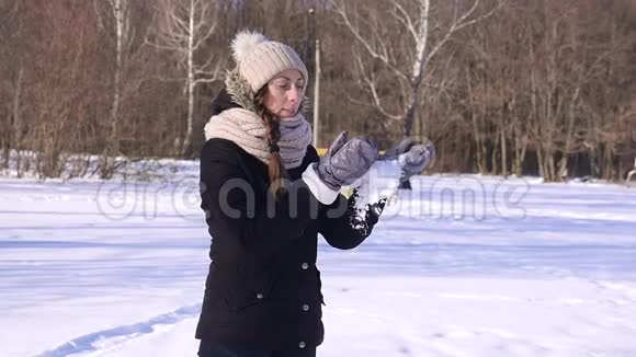 96FPS快乐的年轻女子在冬天的森林里扔雪动作缓慢视频的预览图