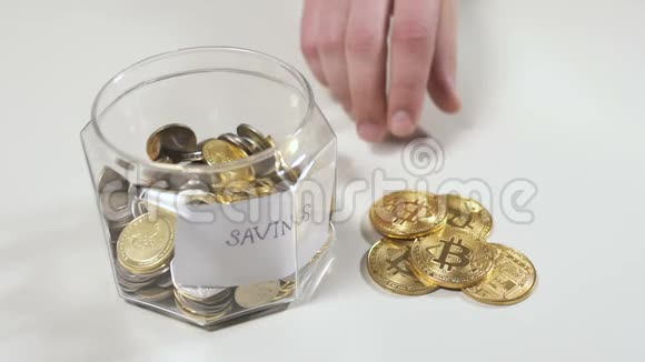 男性手把比特币放进一个玻璃罐子里省钱视频的预览图