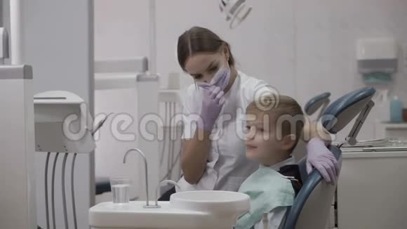 快乐的牙医和小病人显示拇指视频的预览图