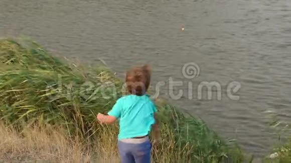 小男孩向湖里扔石头慢悠悠视频的预览图