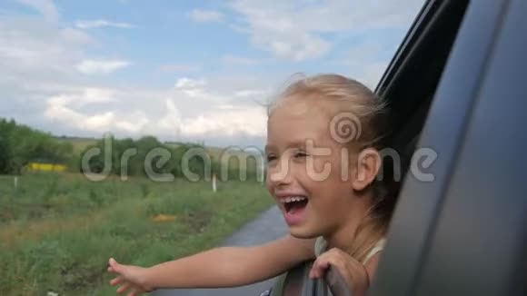 快乐的少女斜靠在车窗外假期概念视频的预览图