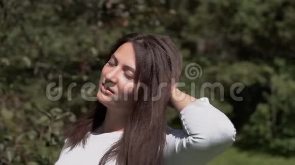 有魅力的女孩在公园里摆姿势慢动作视频的预览图