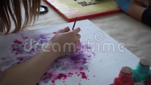 女孩艺术家在彩色板上画字母工艺艺术工作室合作视频的预览图