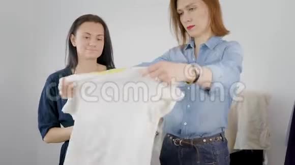 两个女女友拆开衣柜女孩们试着穿不同的衣服决定如何打扮视频的预览图