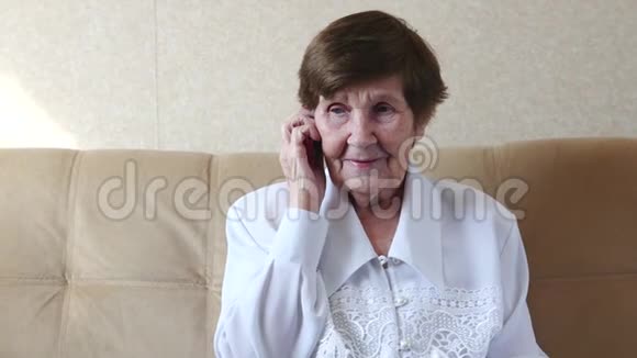 老妇人微笑地在手机上交谈快关门视频的预览图