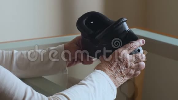年长的女人拿着VR眼镜很老的手女人视频的预览图
