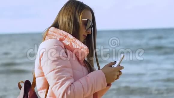 年轻女子在海上射击智能手机视频的预览图