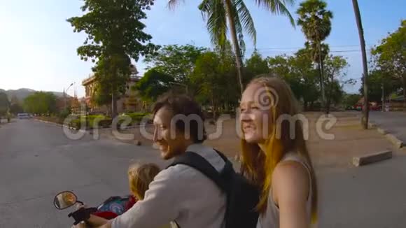 一家人骑着摩托车在普吉的瓦查龙佛教寺庙前自拍的慢镜头视频的预览图