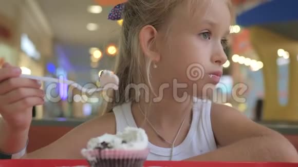 可爱的小女孩正在咖啡馆里吃蛋糕视频的预览图