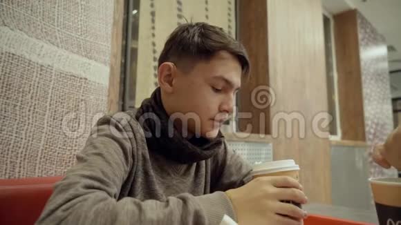 一个患有听力障碍的年轻人从纸杯里喝咖啡视频的预览图