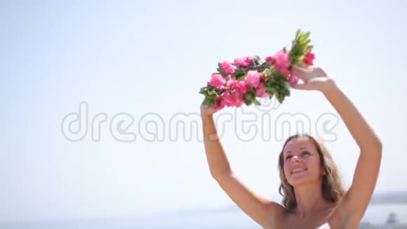 新娘穿着白色连衣裙在海滩上戴着花环视频的预览图