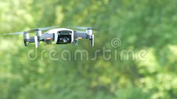 白色的无人机或四架直升机在绿色森林的背景下在空中飞行未来技术视频的预览图