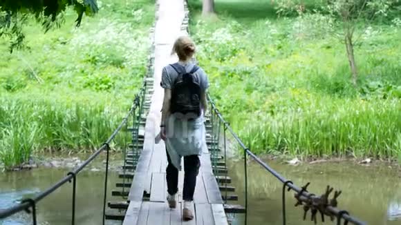 站在横跨山河的桥上的女旅行者视频的预览图